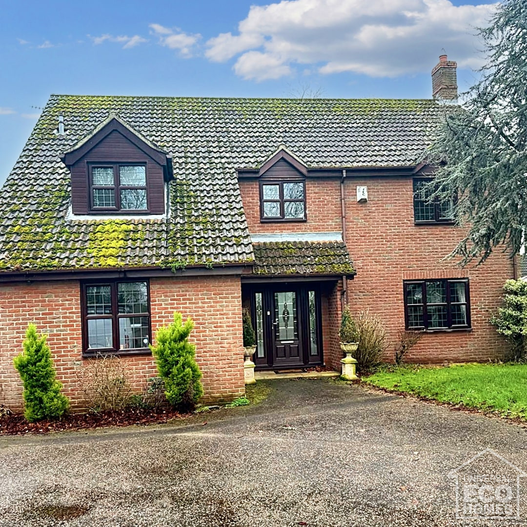 Detached house with moss and algae on roof before roof cleaners get to work 