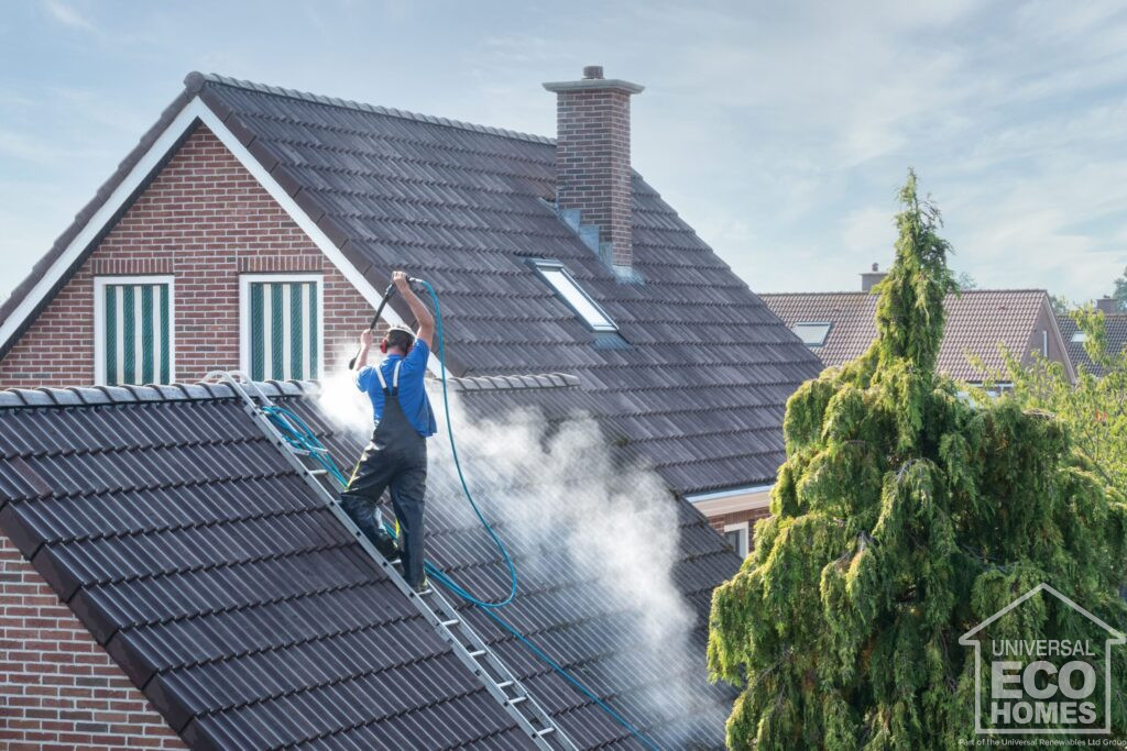 Roof coaters pressure washing roof while on ladder