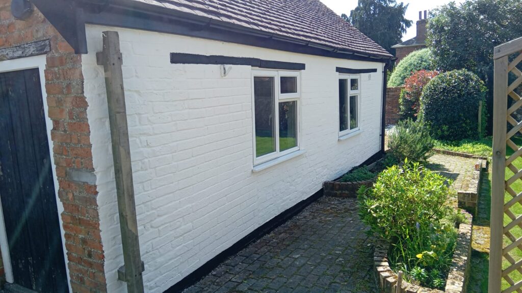 Professional application of wall coating solutions protecting a UK home exterior from winter weather