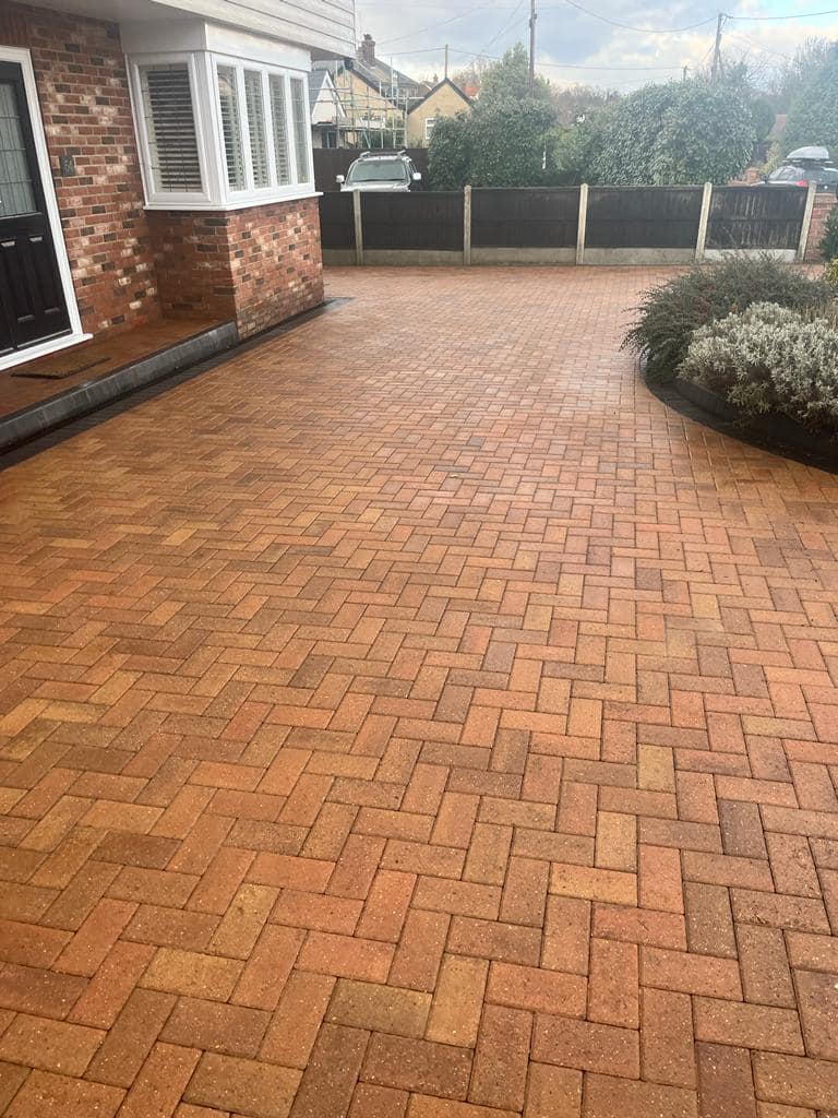 Before and after results of a professional driveway cleaning service removing moss and grime.