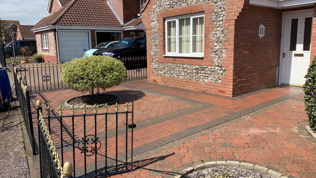 Revitalised driveway in red and grey stone after driveway cleaning services by Universal Eco Homes