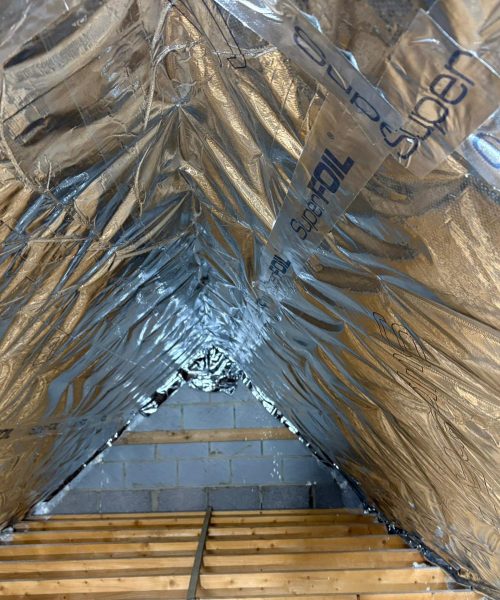 Loft Insulation vs Spray Foam Removal: UK loft insulated with modern foil-based insulation as a safe alternative to spray foam
